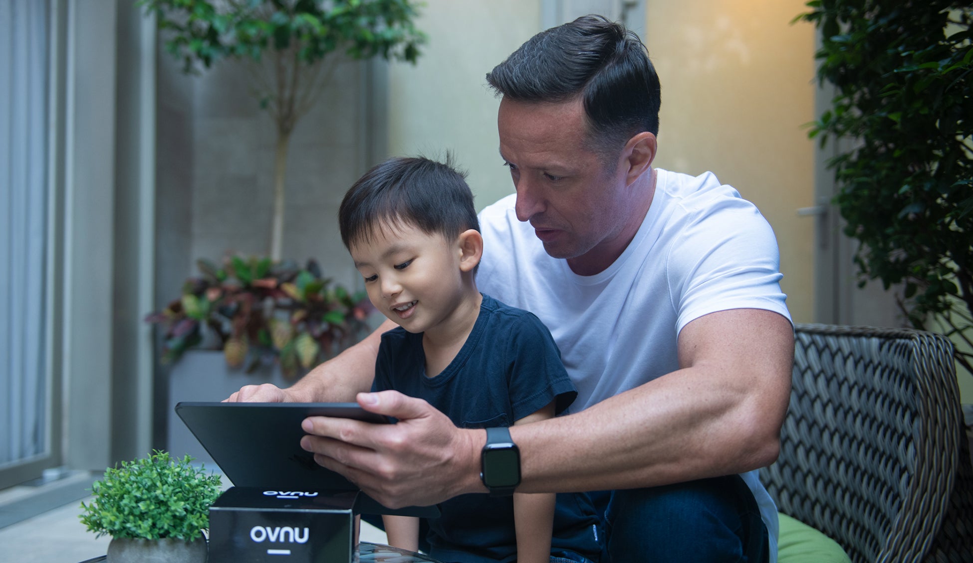 Father helping his son clean his iPad with OVNU Personal Tech Wipes